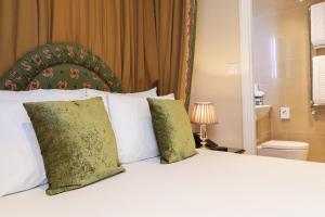 a bedroom with a white bed with two pillows at The Windermere Hotel, London in London