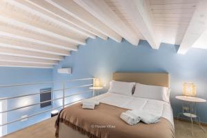 a bedroom with blue walls and a bed with white pillows at House&Villas - Terrazza di Erika in Noto