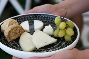 a plate of food with cheese and grapes on it at Kallichoron Art Boutique Hotel in Astypalaia