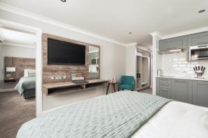 a bedroom with a bed and a television on a wall at The Willows Training Centre in Wyboston