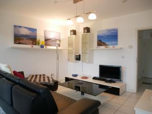ein Wohnzimmer mit Couch und Flachbildfernseher in der Unterkunft Haus Roland- Whg 23 mit Schwimmbad und Sauna in Zinnowitz