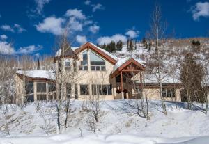 a house in the snow with snow covered trees at 4551 Streamside Cir WEST HOUSE in Vail