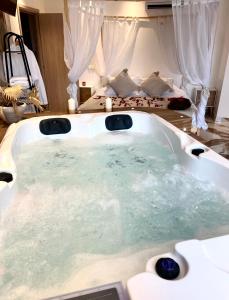 eine Whirlpool-Badewanne in einem Schlafzimmer mit einem Bett in der Unterkunft Studio La Boheme Jacuzzi et Terrasse vu sur Pic Saint Loup in Prades-le-Lez