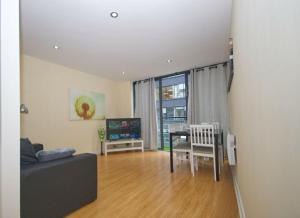 ein Wohnzimmer mit einem Sofa und einem Tisch in der Unterkunft Alluring 2 Bedroom Leeds City Centre Apartment- Self Check-in,Balconied Apartment in Leeds