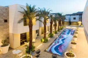 an overhead view of a hotel pool with palm trees at Vivienda Hada Residences in Riyadh
