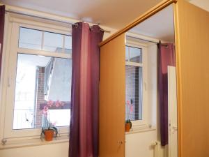 ein Fenster mit roten Vorhängen in einem Zimmer in der Unterkunft Haus Roland- Whg 23 mit Schwimmbad und Sauna in Zinnowitz + 21 Fotos