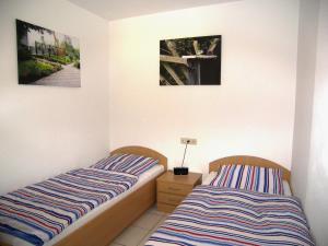 ツィノヴィッツにあるHaus Roland- Whg 23 mit Schwimmbad und Saunaのベッドルーム1室(ベッド2台付)が備わります。壁に2枚の写真が飾られています。