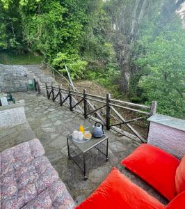 eine Terrasse mit einem Sofa, einem Tisch und einem Zaun in der Unterkunft Βουνό και Θάλασσα I in Xorychti