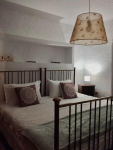 ein Schlafzimmer mit einem Bett mit Kissen und einer Lampe in der Unterkunft Βουνό και Θάλασσα I in Xorychti