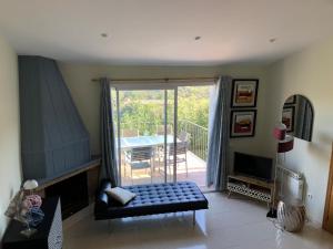 een woonkamer met een bank en een balkon met een tafel bij Villa Rosa in Begur