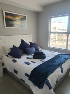 a bedroom with a large bed with blue pillows at 38@Nivica in Langebaan