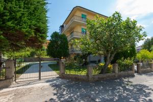 a fence in front of a house with a tree at Marcelli Mare Camere Nel Conero in Numana