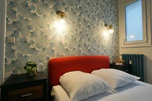 - une chambre avec une tête de lit rouge et un papier peint à fleurs dans l'établissement Le Diplomate *Hyper centre*, à Lorient