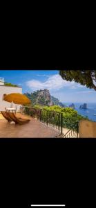 un ombrello giallo seduto su un ponte vicino all'oceano di VILLA OLGA LUXURY CAPRI a Capri
