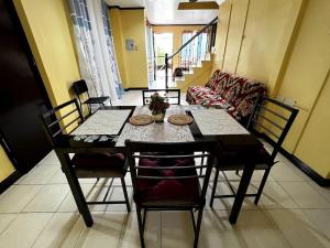 a dining table and chairs in a living room at Lovely 3-Bed House in Talisay Cebu Philippines in Talisay
