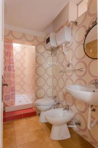 uma casa de banho com 2 WC, um lavatório e uma banheira em Casa Miramare em Mattinata