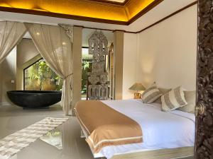 1 dormitorio con 1 cama grande y bañera en Chakra Living Ubud en Ubud