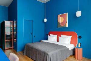 a bedroom with blue walls and a bed with a red headboard at P17 Hotel in Moscow