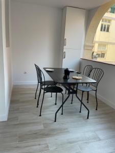 una mesa negra y sillas en una habitación con suelo en Apartamentos Barcelona - Iberia, en Barcelona