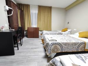 Habitación de hotel con 2 camas y escritorio en Hostal LIWI, en Barcelona