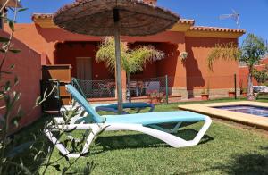 twee stoelen en een paraplu naast een huis bij Casa Maestro Roche in Roche