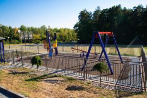 un parque con un parque infantil con dos columpios en Hotel Pasymowski, en Mlawa