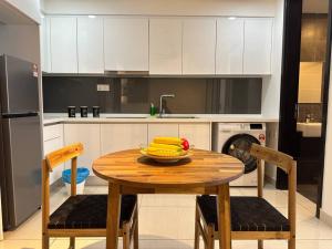 ヌサジャヤにある3003 Almas Suites Modern Netflix 100mbps By STAYの木製テーブル(バナナを入れた台所)