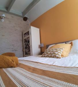 ein Schlafzimmer mit einem großen Bett mit weißer Bettwäsche und Kissen in der Unterkunft La Chouette Burgonde in Villy-le-Moutier