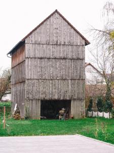 a large wooden barn sitting on top of a field at Willy´s Ferienzimmer im Tabakdorf Hatzenbühl 