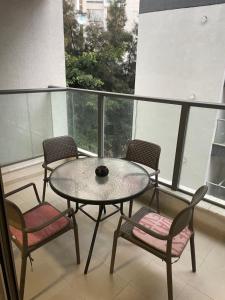 a table and four chairs on a balcony at Family Apartment By IsrApart in Ramat Gan