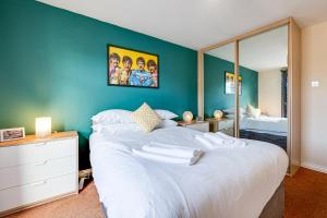 una camera da letto con un grande letto bianco e una parete blu di Cosy 2BR Modern Apt with Free Parking a Liverpool