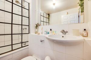 a white bathroom with a sink and a mirror at Cosy 2BR Modern Apt with Free Parking in Liverpool