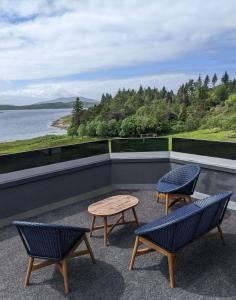 a patio with two chairs and a table on a roof at Loch Melfort Hotel in Ardfern