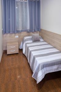 a bedroom with a large bed with blue curtains at ANCLA spaces CON VISTAS AL MAR EGVT436CS in Vinaròs