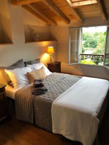 a bedroom with a large bed with a window at La Maison de Mama C: Charming french village home in Sainte-Colombe-sur-lʼHers
