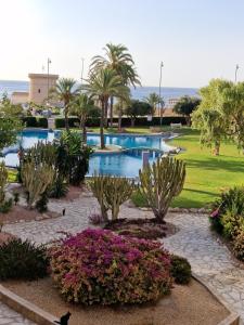 um resort com duas piscinas e árvores e flores em Casa Jayna, Mistral, El Campello em El Campello