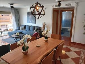 uma sala de estar com uma mesa de madeira e um sofá azul em Casa Jayna, Mistral, El Campello em El Campello
