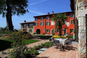 einen Tisch und Stühle vor einem Gebäude in der Unterkunft Residence Borgo Mondragon in Lazise