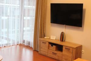ein Wohnzimmer mit einem Flachbild-TV an der Wand in der Unterkunft OK Apartament Uzdrowiskowa in Świnoujście