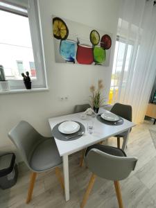 別爾斯科－比亞瓦的住宿－!KOMFORT APARTAMENT KUSTRONIA Garaż Balkon Wanna，一张带两把椅子和盘子的白色桌子