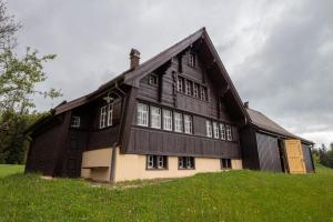 un grande edificio in legno in cima a una verde collina di Ferienhaus Fromsenrüti a Walzenhausen