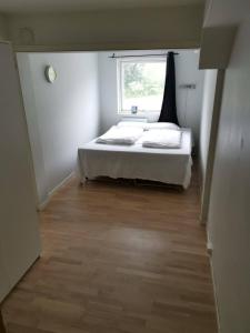 a small bedroom with a bed and a window at Big, spacious apartment with free parking in Tromsø