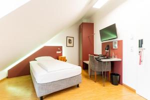 エアランゲンにあるAltstadthotel Grauer Wolfのベッドルーム1室(ベッド1台、デスク、コンピュータ付)