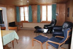 a living room with leather chairs and a table at Leinacherhof - Ferienwohnung für 2 Erwachsene und 3 Kinder 