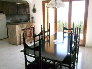 a dining room with a table and a kitchen at La gervaise in Begur