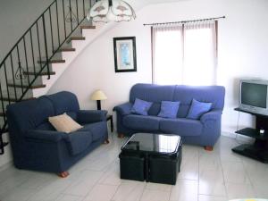 a living room with two blue couches and a staircase at La gervaise in Begur