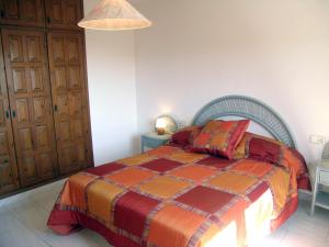 a bedroom with a bed with a red and orange blanket at La gervaise in Begur +16 photos