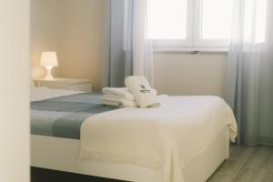 - une chambre blanche avec un lit et des serviettes dans l'établissement Best Houses 53 - Costa Mar II, à Consolação