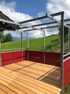a pergola on a deck with a view of a field at Unterkunft MECK-HEI in Wildhaus