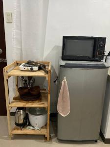 a microwave sitting on top of a refrigerator at The Tiny Room Apartment Units near Anonas and Cubao in Manila